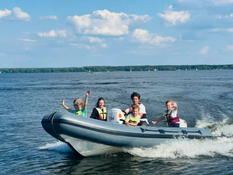 Dzieci na motorówce na półkoloniach żeglarskich Lion Sailing nad Zalewem Zegrzyńskim